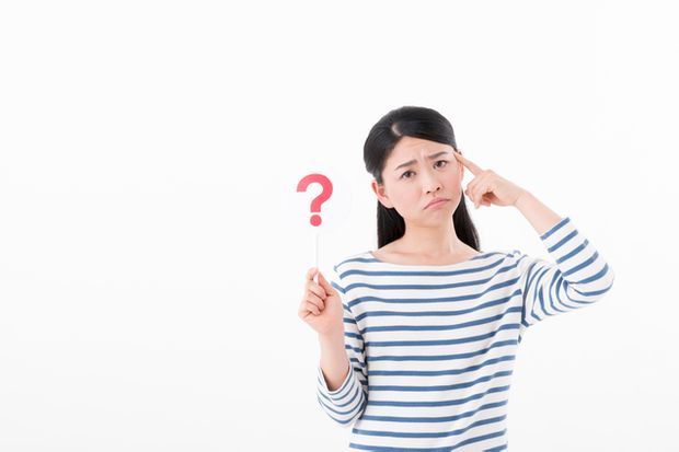 はてなマークを掲げた女性