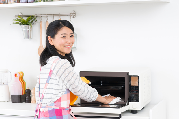 電子レンジを拭き掃除する女性