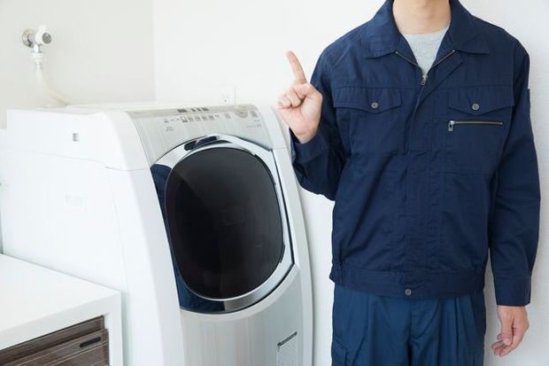 洗濯機の前に立つ事業者スタッフ