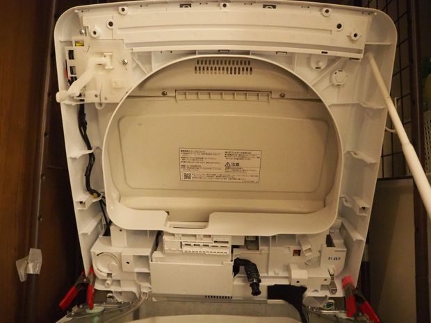 洗濯機のカバーを上にあげている画像