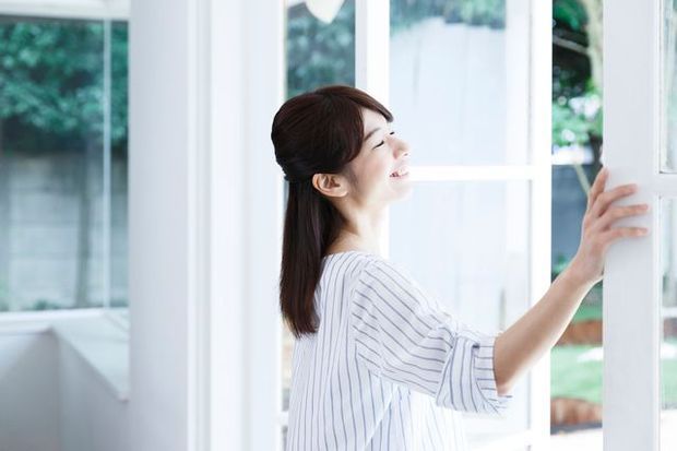 窓を開ける女性