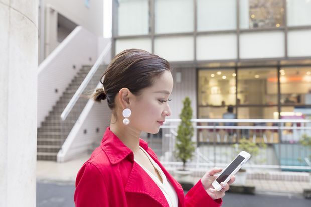 外出先でスマホをチェックする女性