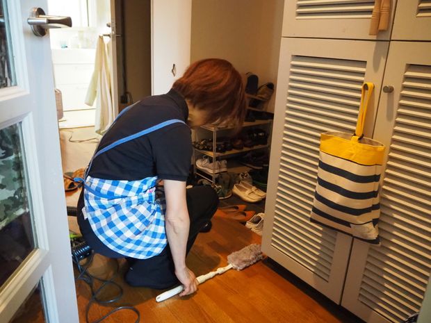 玄関を掃除する女性