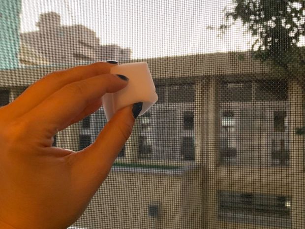 網戸をメラニンスポンジで拭いている
