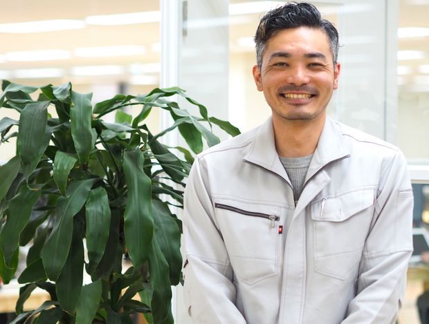 木のそばで笑顔で立つ男性