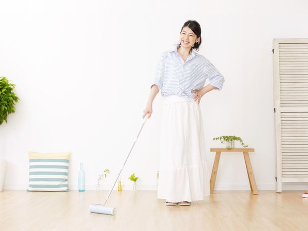 柄の長いコロコロを持つ女性