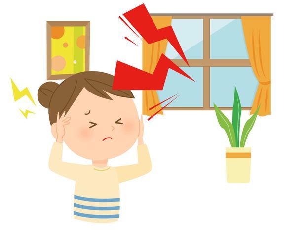 うるさい音に耳を塞ぐ女性