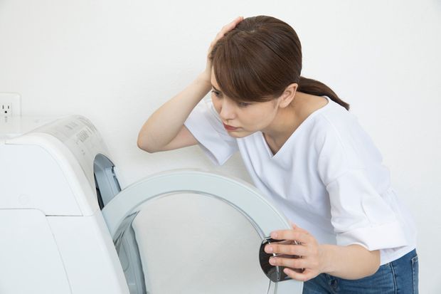 洗濯機の中を覗き込む女性