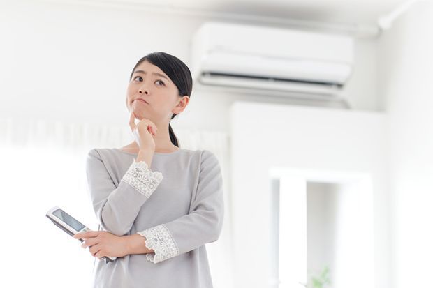 エアコンの前で困る女性