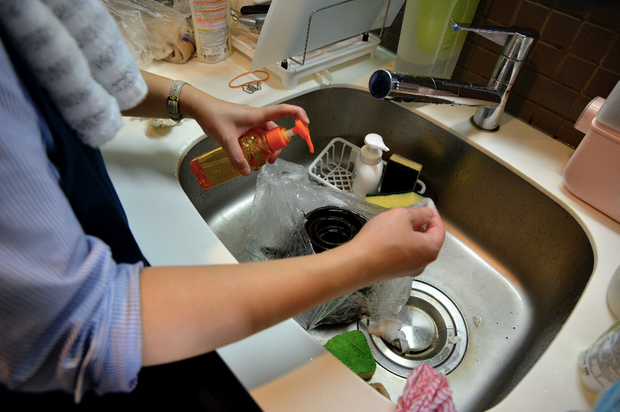 五徳に中性洗剤をかける女性
