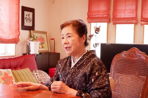 部屋の中で座っている着物の女性