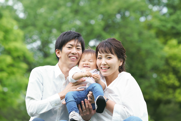 笑顔で赤ちゃんを抱っこする夫婦
