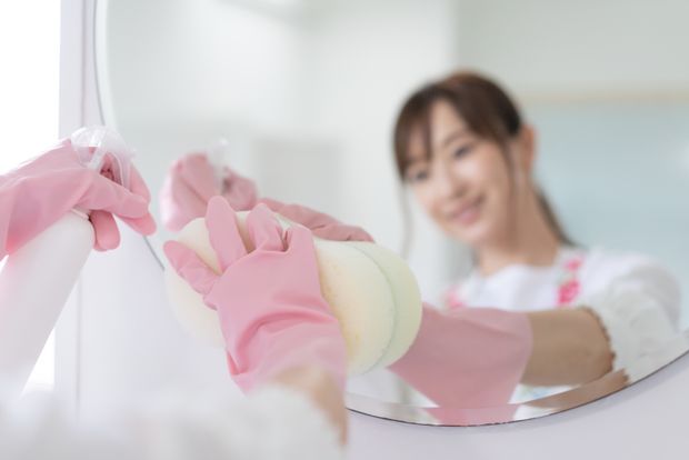 洗面所を掃除する若い女性