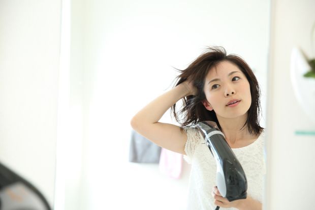 洗面所でドライヤーする女性