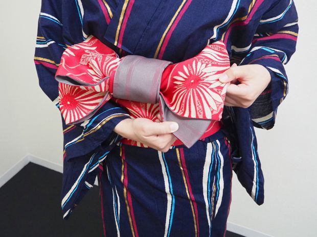 下側の帯を下げる女性