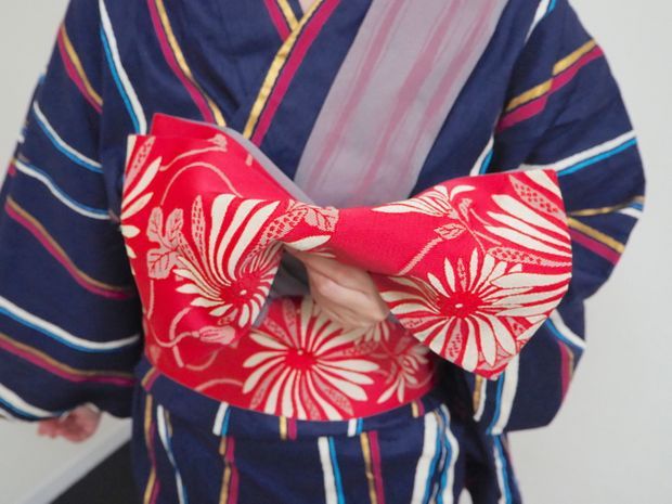 じゃばら折りにした帯を山折にする女性