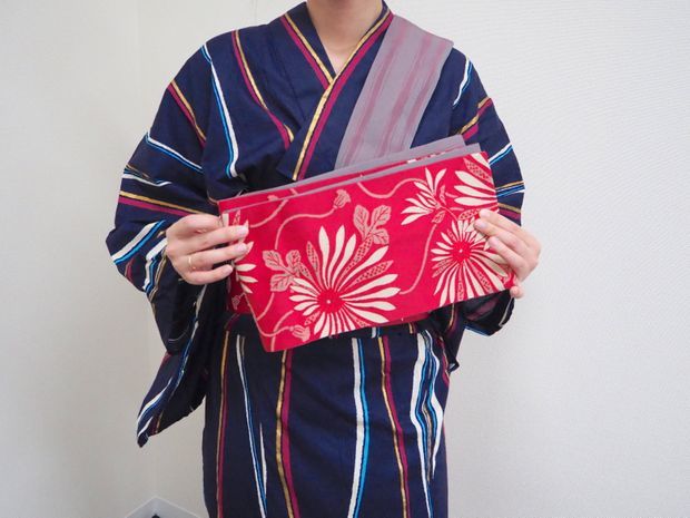 帯をじゃばら折りにする女性