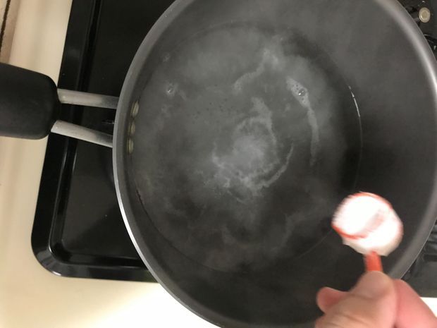 お湯に重曹の粉大さじ5〜6杯を少しずつ入れる場面