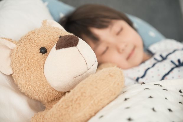 ぬいぐるみをだっこして寝る子供