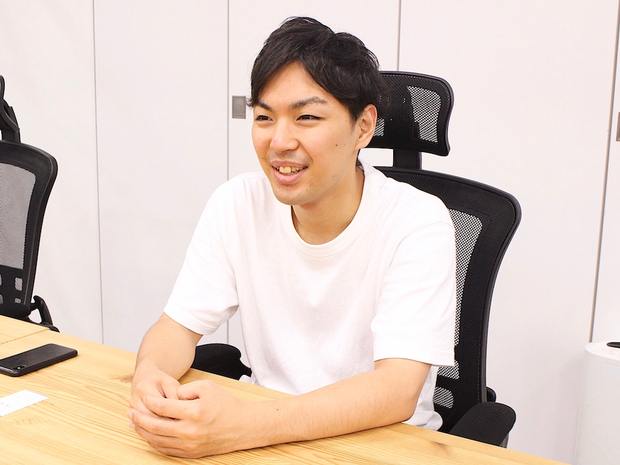 パソコンの前で笑いながら話す廣澤さん