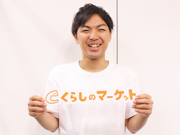 くらしのマーケットのパネルを持って笑う廣澤さん